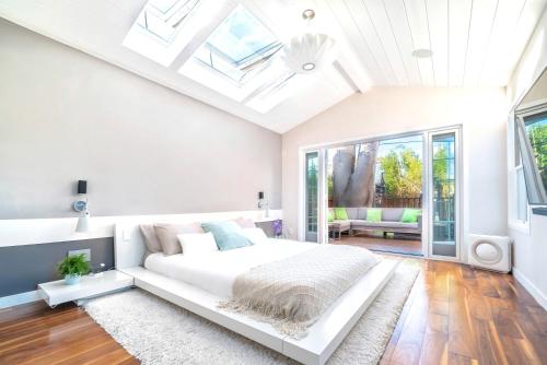a white bedroom with a bed and a skylight at Bright European House In Venice Beach 2bdr in Los Angeles