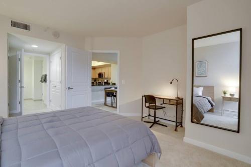 a bedroom with a bed and a desk and a mirror at Fantastic 2 BR Condo At Pentagon CIty with Pool&Gym in Arlington