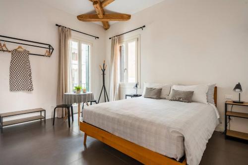 a white bedroom with a large bed and a table at Hinc Domus - Venezia Historical City Center in Venice