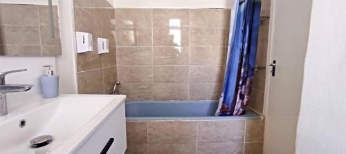 ein Badezimmer mit einer Dusche und einer blauen Badewanne in der Unterkunft Sea View 2 bedroom apartment in Marsaskala