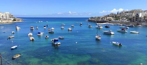 a group of boats in a large body of water at Sea View 2 bedroom apartment in Marsaskala