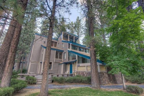 une grande maison dans les bois avec des arbres dans l'établissement Lucky Lady 404 home, à South Lake Tahoe