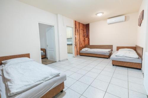 1 dormitorio con 2 camas y suelo de baldosa en Keletiparty, en Hajdúszoboszló