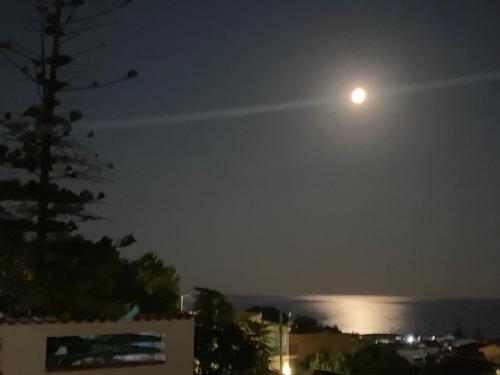 a full moon over the water at night at Nora's Flats in Triscina