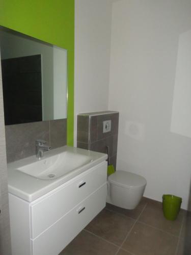Un baño con lavabo, inodoro y espejo. en Arinella Villas, en Farinole