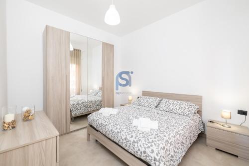a bedroom with a bed and a large mirror at Al Posto Giusto - Self Check in in Cefalù