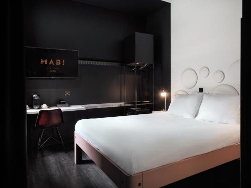 a bedroom with a white bed and a desk at MABI City Centre in Maastricht