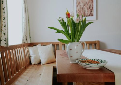 a table with a vase of flowers on top of it at Mühlbauerhof in Großklein