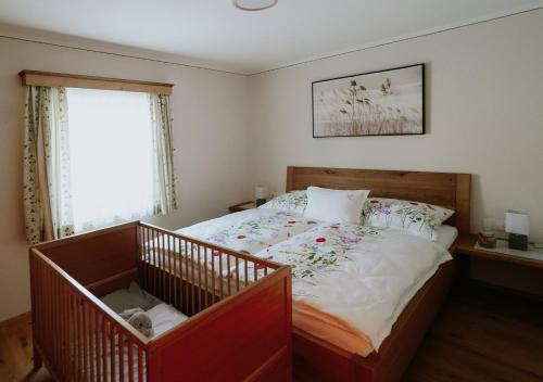 a bedroom with a bed with a crib in it at Mühlbauerhof in Großklein