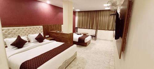 a hotel room with two beds and a chair at Mayda Inn- A Boutique Hotel in New Delhi