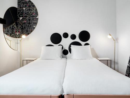 two beds in a bedroom with black and white at MABI City Centre in Maastricht