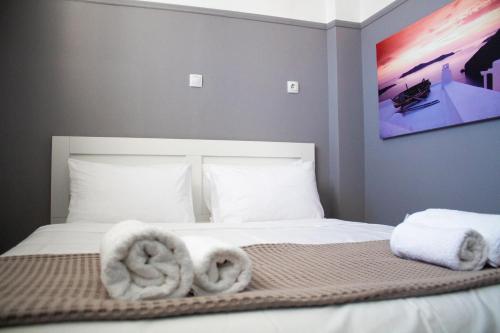 EMVI APARTMENTS III seaview near airport في أرتيميدا: غرفة نوم عليها سرير وفوط