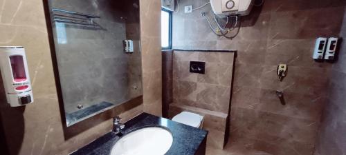 a bathroom with a sink and a shower and a toilet at Mayda Inn- A Boutique Hotel in New Delhi