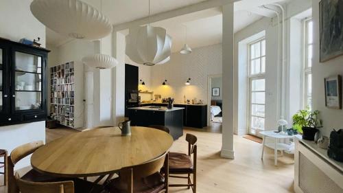 a living room with a wooden table and a kitchen at ApartmentInCopenhagen Apartment 1439 in Hellerup