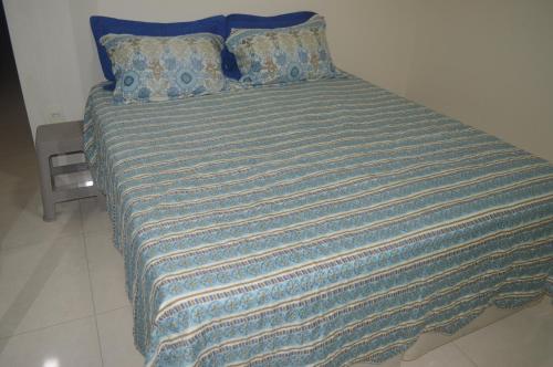 瓜拉派瑞Edifício Corte Real的一张带蓝色毯子和枕头的大床