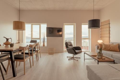 New Aparthotel / Panoramic sea view في تورشافن: غرفة معيشة مع طاولة وكراسي وأريكة