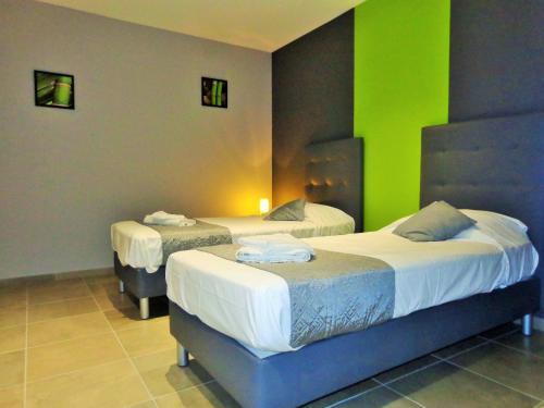 Dos camas en una habitación con paredes verdes. en Arinella Villas, en Farinole