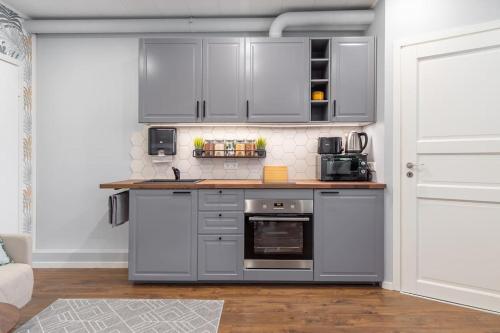 a kitchen with stainless steel appliances and white cabinets at Romantic studio apartment - private entrance! in Pärnu