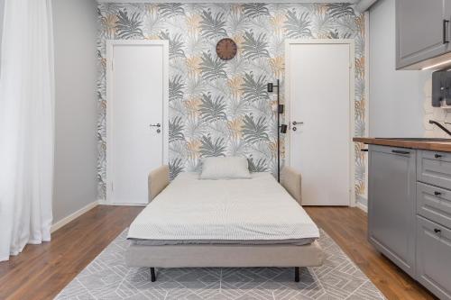 a bed in a room with two doors at Romantic studio apartment - private entrance! in Pärnu