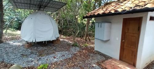 a house with a large umbrella next to a door at Hotel Cariguá in Barichara