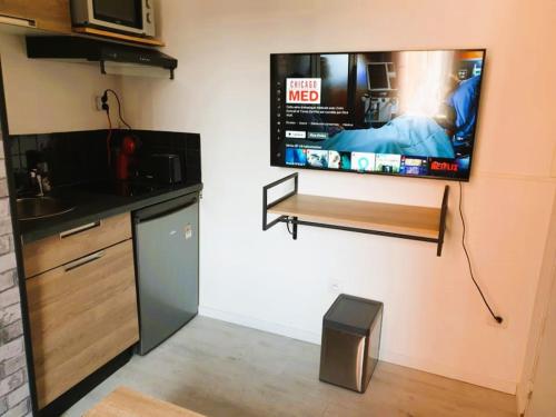 Il dispose d'une cuisine avec une télévision murale à écran plat. dans l'établissement STUDIO LE PETIT ATELIER - PROCHE GARE - WiFi, à Amiens