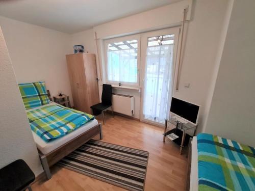 a bedroom with a bed and a tv and a window at Ferienhaus Clarissa in Allenbach