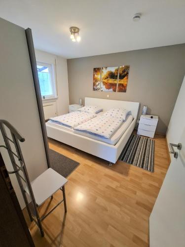 a bedroom with a bed and a chair in it at Ferienhaus Clarissa in Allenbach