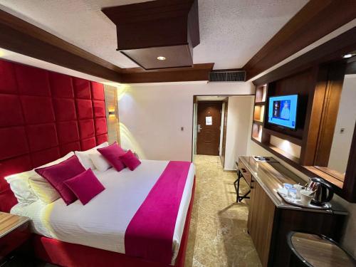 a hotel room with a large bed and a flat screen tv at Petra Sella Hotel in Wadi Musa