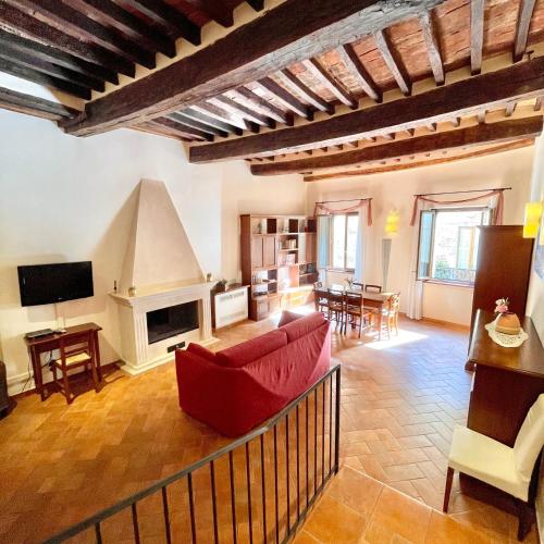 a living room with a red couch and a fireplace at La Dimora nel Corso in Montepulciano