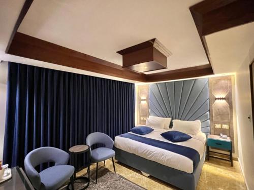 una camera da letto con letto, cuscini e sedie blu di Petra Sella Hotel a Wadi Musa
