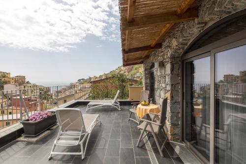 - un balcon avec des chaises et une table dans un bâtiment dans l'établissement Locanda Ca Da Iride, à Riomaggiore
