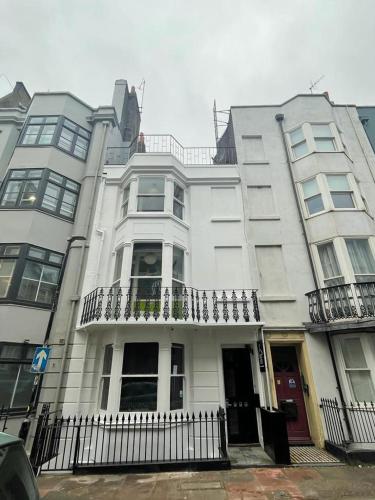 a large white building with a balcony on a street at Guest And The City in Brighton & Hove