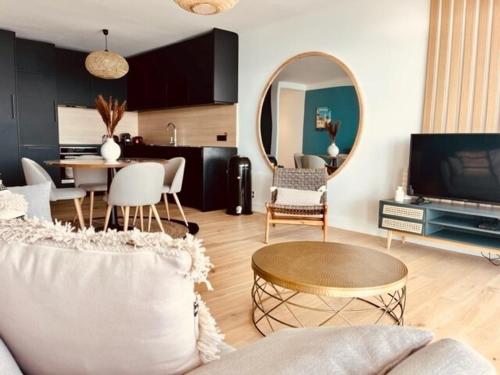 un salon avec un canapé, une table et un miroir dans l'établissement Les Baux 3, à Sanary-sur-Mer