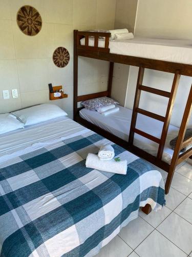 a bedroom with two bunk beds with towels at Estalagem Sol de Boipeba in Ilha de Boipeba