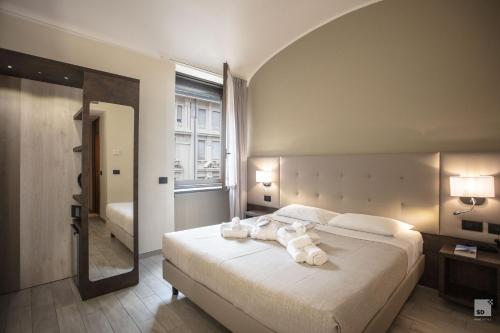 都靈的住宿－外交官酒店，一间卧室配有一张大床和毛巾
