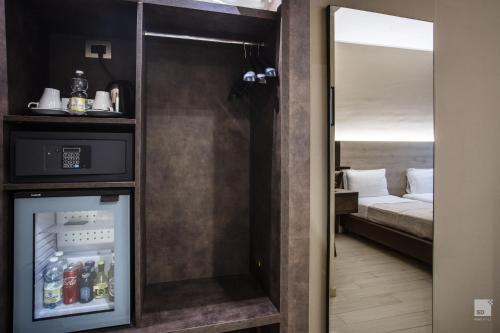 a door leading to a room with a bed and a refrigerator at Hotel Diplomatic in Turin