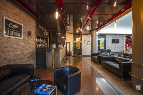 a lobby with leather couches and a bar at Hotel Diplomatic in Turin