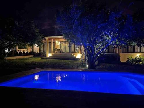 - une piscine bleue devant une maison la nuit dans l'établissement VillaFour@Tsai-Tsai, à Vilanculos
