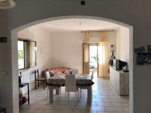 ein Wohnzimmer mit einem Tisch und einem Sofa in der Unterkunft Casa Marchello in Castrignano del Capo