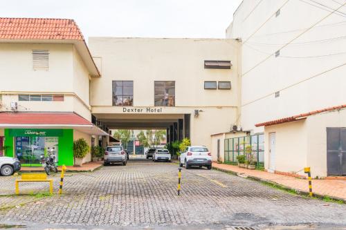 a parking lot with cars parked in front of a building at Dexter Hotel - Volta Redonda in Volta Redonda