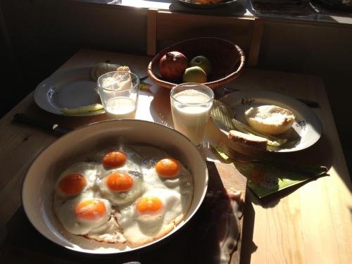 a table with a bowl of eggs and bread and glasses of milk at Vida-lak in Berekfürdő