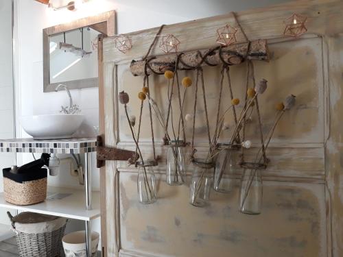 a bathroom with several glass vases on the wall at les Métras in Ceyzériat