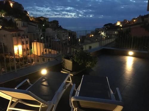 a patio with chairs and a table on a balcony at night at Locanda Ca Da Iride in Riomaggiore