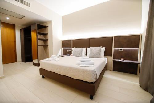 a bedroom with a large bed with towels on it at Hotel Diplomatic in Turin