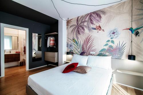 a bedroom with a large white bed with a painting on the wall at Sette - by MyHomeInComo in Como