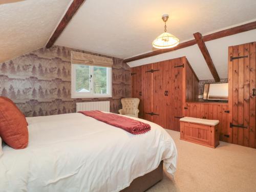 韋茅斯的住宿－The Grain Store，一间带一张大床的卧室,位于带木墙的房间