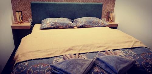ein Bett mit zwei Kissen und Handtüchern darauf in der Unterkunft Apartman Lenka Zlatar in Nova Varoš