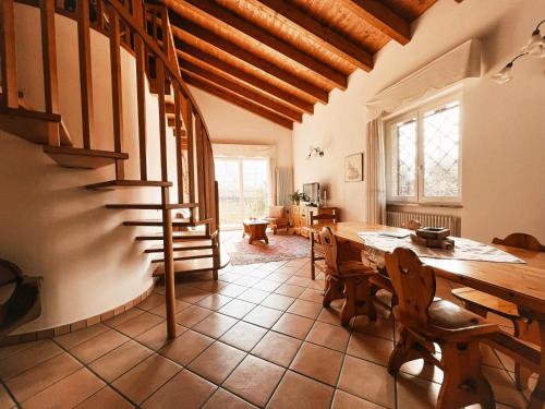 a dining room with a table and a staircase at Relais diVINO in Ala