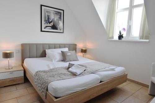 een slaapkamer met een bed in een kamer met een raam bij PASTORI - Das historische Lichtspielgasthaus in Weilmünster