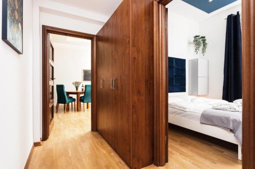1 dormitorio con 1 cama y puerta de madera en Apartament Vinci, en Cracovia